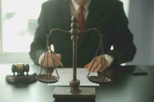 Business and lawyers discussing contract papers with brass scale on desk in office. Law, legal services, advice, justice and law concept picture with film grain effect photo