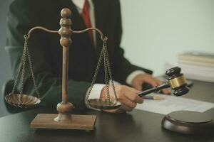 Business and lawyers discussing contract papers with brass scale on desk in office. Law, legal services, advice, justice and law concept picture with film grain effect photo