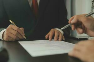 Business and lawyers discussing contract papers with brass scale on desk in office. Law, legal services, advice, justice and law concept picture with film grain effect photo