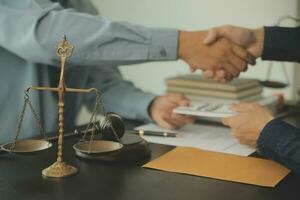 Business and lawyers discussing contract papers with brass scale on desk in office. Law, legal services, advice, justice and law concept picture with film grain effect photo