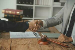 Business and lawyers discussing contract papers with brass scale on desk in office. Law, legal services, advice, justice and law concept picture with film grain effect photo