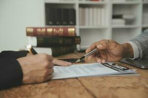 Business and lawyers discussing contract papers with brass scale on desk in office. Law, legal services, advice, justice and law concept picture with film grain effect photo