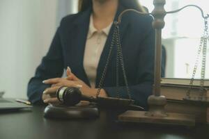 Justice and law concept.Male judge in a courtroom with the gavel, working with, computer and docking keyboard, eyeglasses, on table in morning light photo