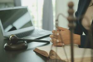 Justice and law concept.Male judge in a courtroom with the gavel, working with, computer and docking keyboard, eyeglasses, on table in morning light photo