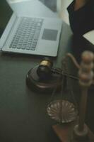 Justice and law concept.Male judge in a courtroom with the gavel, working with, computer and docking keyboard, eyeglasses, on table in morning light photo