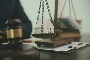 Justice and law concept.Male judge in a courtroom with the gavel, working with, computer and docking keyboard, eyeglasses, on table in morning light photo