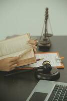 Justice and law concept.Male judge in a courtroom with the gavel, working with, computer and docking keyboard, eyeglasses, on table in morning light photo