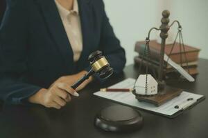 Justice and law concept.Male judge in a courtroom with the gavel, working with, computer and docking keyboard, eyeglasses, on table in morning light photo