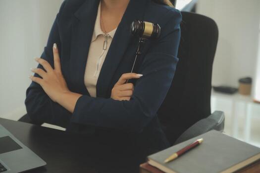 Justice and law concept.Male judge in a courtroom with the gavel, working with, computer and docking keyboard, eyeglasses, on table in morning light photo