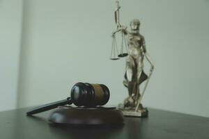 Justice and law concept.Male judge in a courtroom with the gavel, working with, computer and docking keyboard, eyeglasses, on table in morning light photo