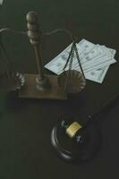 Justice and law concept.Male judge in a courtroom with the gavel, working with, computer and docking keyboard, eyeglasses, on table in morning light photo