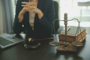 Justice and law concept.Male judge in a courtroom with the gavel, working with, computer and docking keyboard, eyeglasses, on table in morning light photo