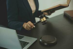 Justice and law concept.Male judge in a courtroom with the gavel, working with, computer and docking keyboard, eyeglasses, on table in morning light photo