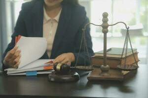 Justice and law concept.Male judge in a courtroom with the gavel, working with, computer and docking keyboard, eyeglasses, on table in morning light photo