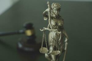 Justice and law concept.Male judge in a courtroom with the gavel, working with, computer and docking keyboard, eyeglasses, on table in morning light photo