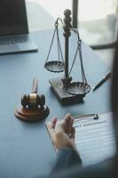 Justice and law concept.Male judge in a courtroom with the gavel, working with, computer and docking keyboard, eyeglasses, on table in morning light photo