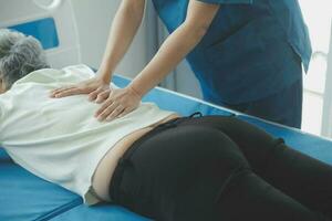Physiotherapist working with patient in clinic, closeup photo