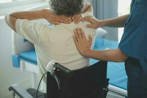 young asian physical therapist working with senior woman on walking with a walker photo