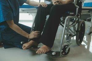 young asian physical therapist working with senior woman on walking with a walker photo