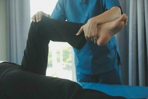 Physiotherapist working with patient in clinic, closeup photo