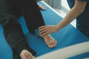 Physiotherapist working with patient in clinic, closeup photo