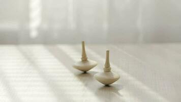 Two small spinning top moving on a table with negative space. video