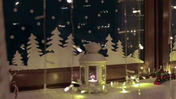 Noël ornements et lumière réfléchi sur le fenêtre à nuit derrière transparent rideau video