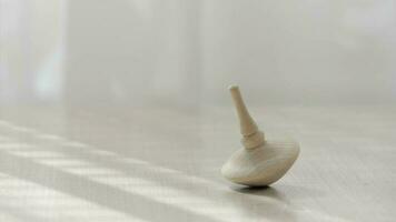 Small spinning top moving on a table. Closeup video