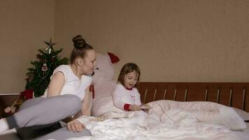 Young mother between 30 and 35 years old shows wooden box with her old photos to her small children video