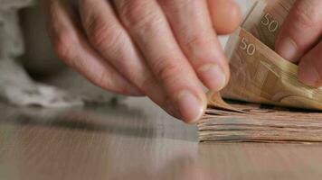 Female hand counting Euro banknotes on the office table. close up video