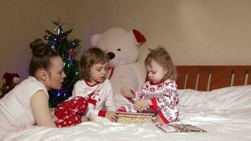 Young mother shows wooden box with old photos to her small children video