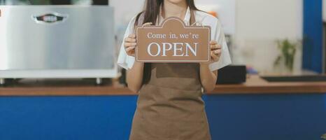 joven asiático comienzo arriba pequeño negocio propietario abierto el café tienda y restaurante. pequeño negocio propietario y Servicio mente. foto