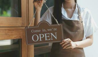 joven asiático comienzo arriba pequeño negocio propietario abierto el café tienda y restaurante. pequeño negocio propietario y Servicio mente. foto