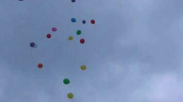 coloré des ballons en volant en haut à le nuageux bleu ciel video