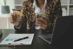 Women holding credit card and using smartphones at home.Online shopping, internet banking, store online, payment, spending money, e-commerce payment at the store, credit card, concept photo