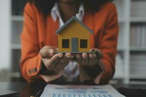 Female woman hands holding home model, small miniature white toy house. Mortgage property insurance dream moving home and real estate concept photo