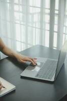 Shot of a asian young business Female working on laptop in her workstation. photo