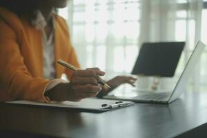 Portrait of Asian young female working on laptop at office photo