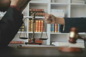 Justice and law concept.Male judge in a courtroom with the gavel, working with, computer and docking keyboard, eyeglasses, on table in morning light photo