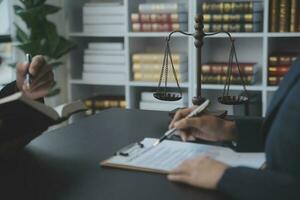 Business and lawyers discussing contract papers with brass scale on desk in office. Law, legal services, advice, justice and law concept picture with film grain effect photo