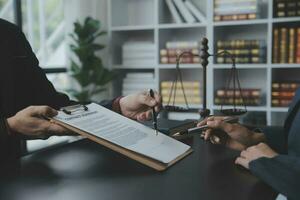 Business and lawyers discussing contract papers with brass scale on desk in office. Law, legal services, advice, justice and law concept picture with film grain effect photo