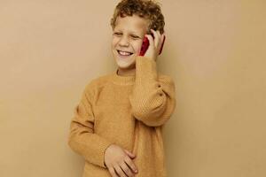 Cheerful boy talking on the phone on a beige background photo