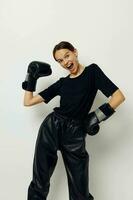 hermosa niña en boxeo guantes en negro pantalones y un camiseta aptitud formación foto