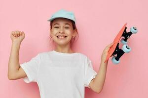 Portrait of happy smiling child girl with a skateboard in hand isolated background photo