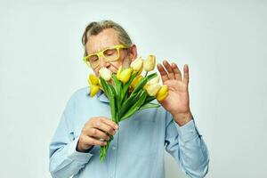 Photo of retired old man yellow bouquet of flowers posing light background