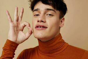 A young man brown turtleneck posing fashion light background unaltered photo