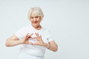 Portrait of an old friendly woman in a white t-shirt light background photo