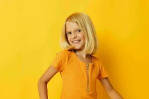 Young blonde girl in a yellow t-shirt smile posing studio childhood lifestyle unaltered photo