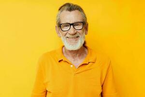 Portrait of happy senior man wearing glasses yellow shirt posing unaltered photo