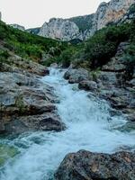 Small waterfall at the bottom of the mountain photo